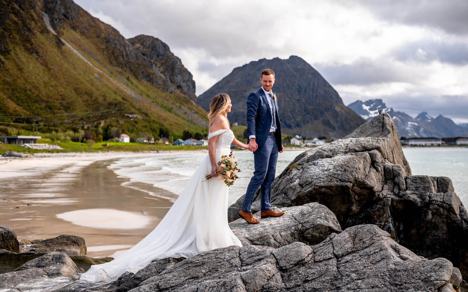 Elopement couple walking on a rock at a beach at Lofoten islands