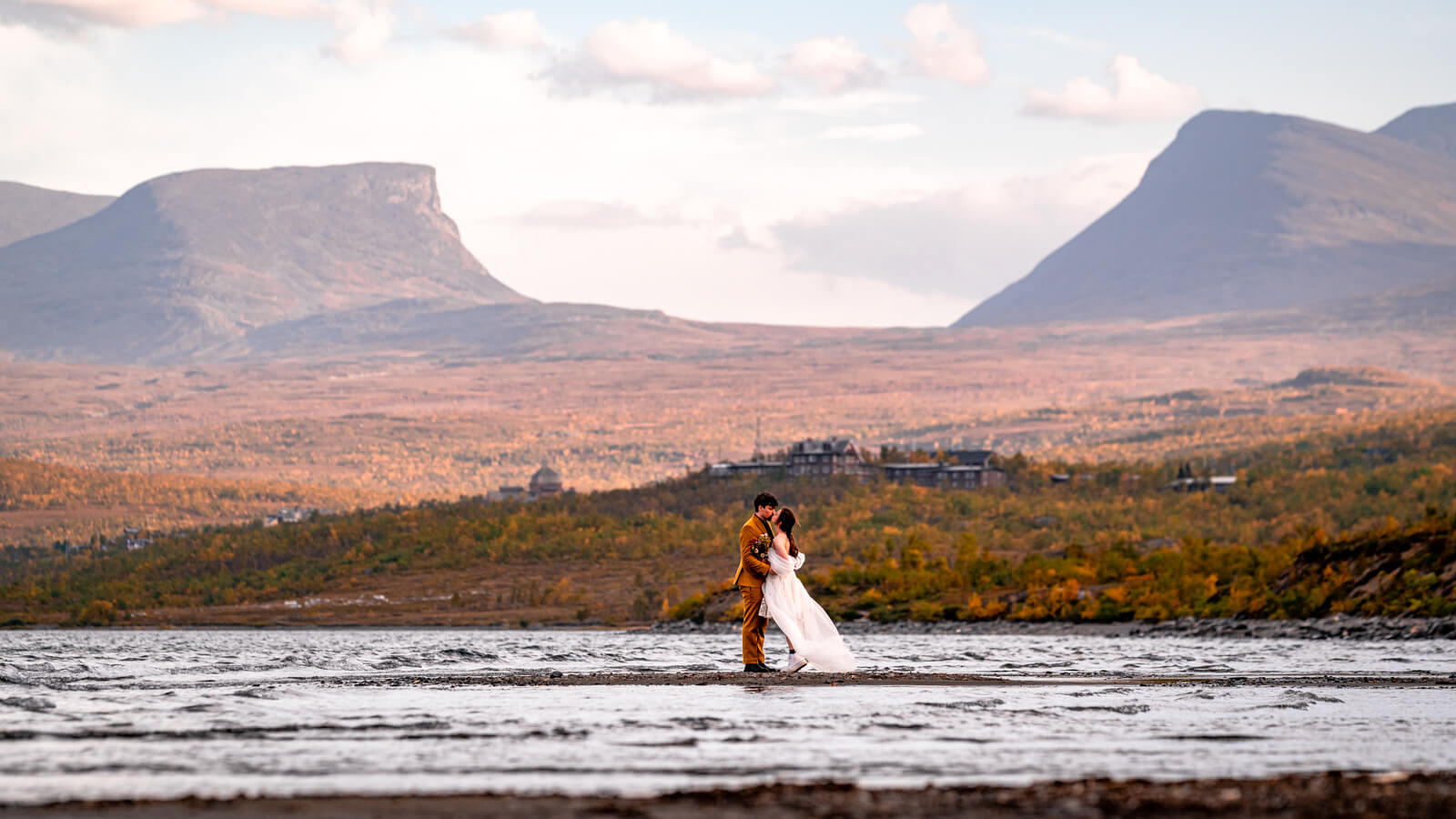 Eloping couple kissing under Lappland gate at Abisko national park