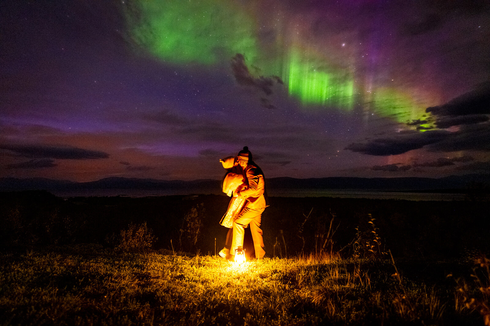 Wedding couple under dancing aurora borealis